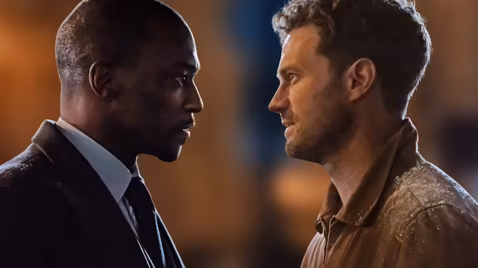 Two men stand face to face in a tense nighttime confrontation