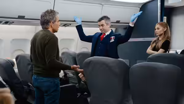 Greg Focker (Ben Stiller) facing a flight attendant while Olivia Jones watches