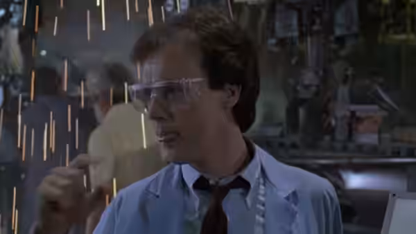Jack (Michael Keaton) wears safety glasses in a workshop as sparks fly around him