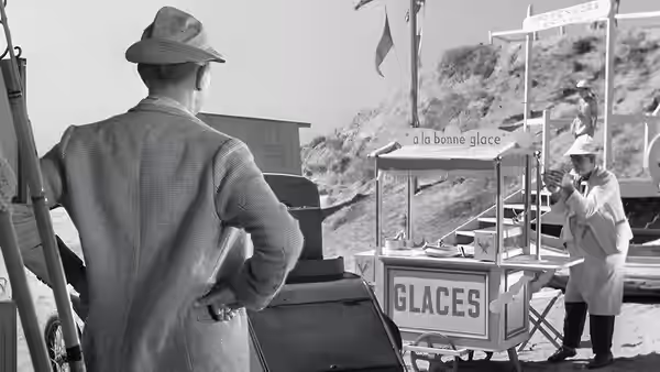 Monsieur Hulot (Jacques Tati) faces an ice cream vendor beside the GLACES cart