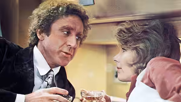 George Caldwell talks with Hilly Burns as they hold drinks