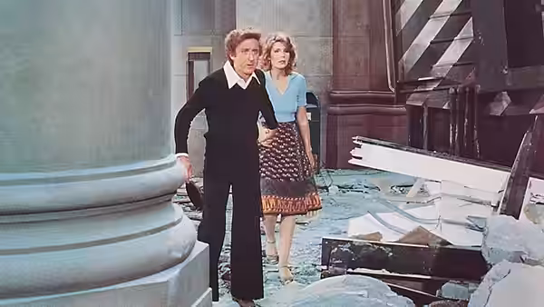 George Caldwell and Hilly Burns stand amid rubble inside a damaged building