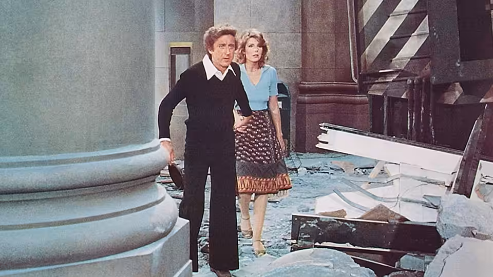 George Caldwell and Hilly Burns stand amid rubble inside a damaged building
