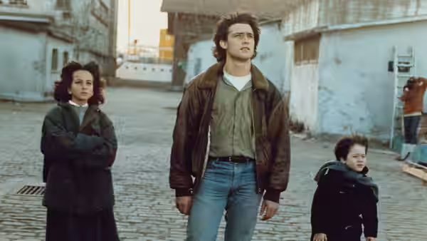 Voula and Alexandros stand beside Orestis on a cobbled village street
