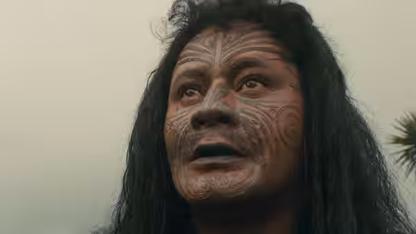 Te Wheke (Anzac Wallace) looks upward, his face marked with tā moko