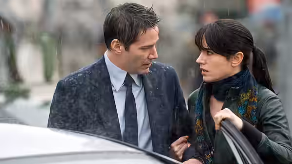 Klaatu (Keanu Reeves) and Helen Benson (Jennifer Connelly) talking by a car in the rain