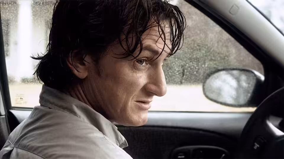 Paul Rivers (Sean Penn) behind the wheel of a car