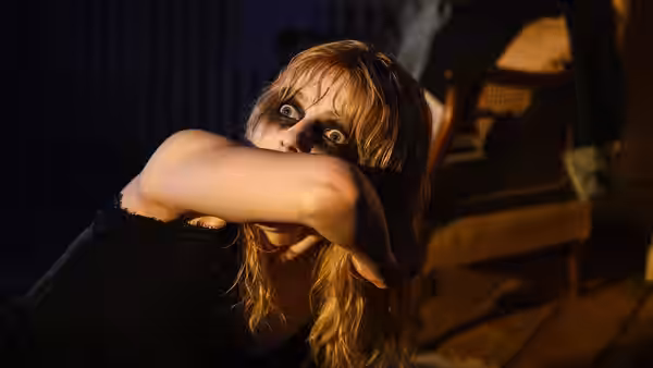 Sandie (Anya Taylor-Joy) with messy hair staring forward in a dark room