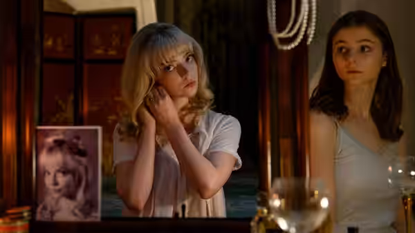 Sandie (Anya Taylor-Joy) and Eloise (Thomasin McKenzie) standing before a vanity mirror