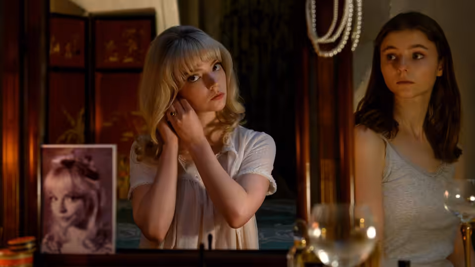 Sandie (Anya Taylor-Joy) and Eloise (Thomasin McKenzie) standing before a vanity mirror
