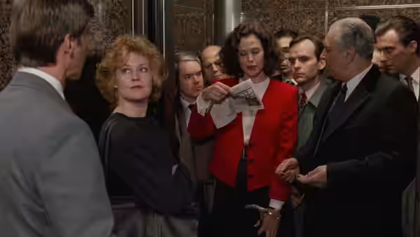 Katharine Parker (Sigourney Weaver) points to a newspaper in an elevator as Tess McGill (Melanie Griffith) watches