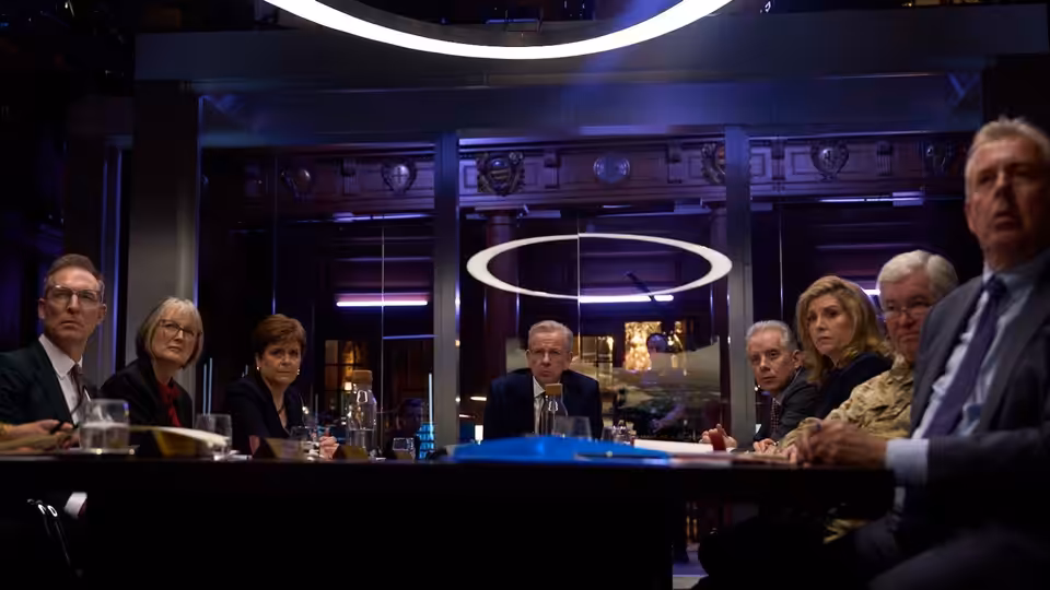 Officials seated around a long table in a modern conference room