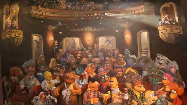 A crowd of Muppets gathers inside an ornate theater