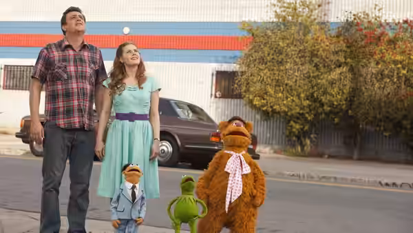 Gary (Jason Segel), Mary (Amy Adams), Walter (Peter Linz), Kermit and Fozzie stand outside a building
