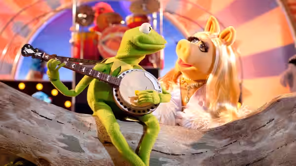 Kermit (Steve Whitmire) plays banjo beside Miss Piggy (Eric Jacobson) onstage