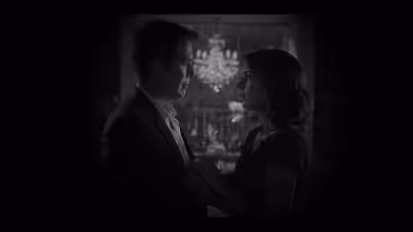 Benedick (Alexis Denisof) and Beatrice (Amy Acker) standing close in shadow