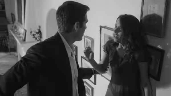 Benedick (Alexis Denisof) and Beatrice (Amy Acker) facing each other in a hallway