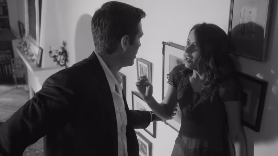 Benedick (Alexis Denisof) and Beatrice (Amy Acker) facing each other in a hallway