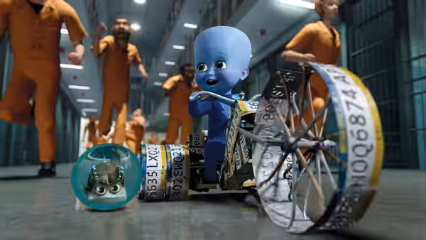 Young Megamind and Minion roll through a prison corridor as inmates run past