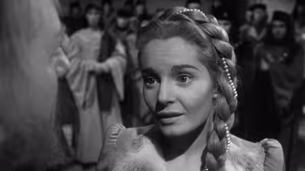 Desdemona (Suzanne Cloutier) looks up with concern in a crowded hall