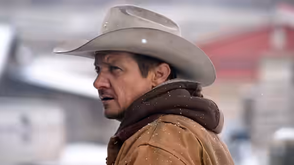 Cory Lambert (Jeremy Renner) wears a cowboy hat in falling snow