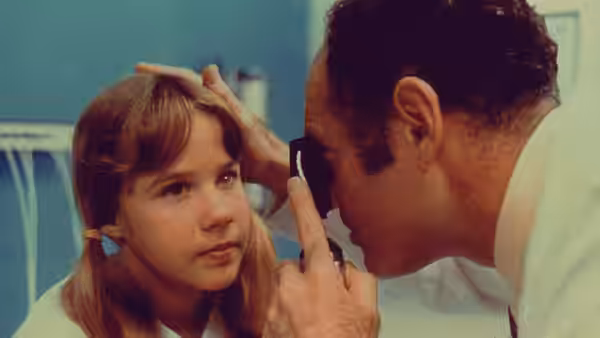 Regan MacNeil (Linda Blair) has her eye checked by Dr. Klein (Barton Heyman)