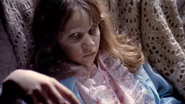 Regan MacNeil (Linda Blair) lies in bed with wide eyes and messy hair