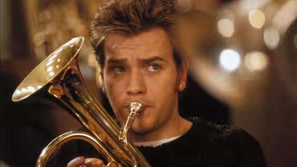 Andy (Ewan McGregor) playing a cornet in a close-up portrait