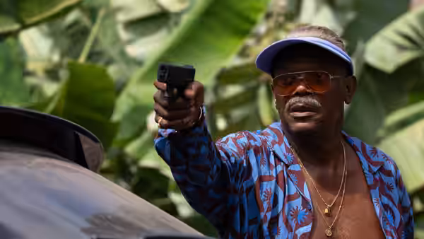 Jack Wolfe (Samuel L. Jackson) aiming a handgun from behind a vehicle