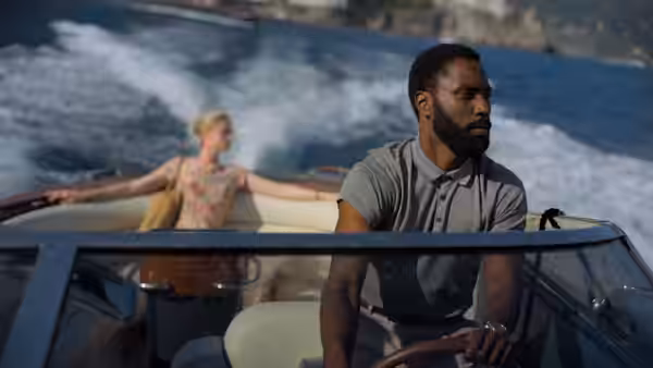 Protagonist (John David Washington) steering a speedboat with Kat (Elizabeth Debicki) aboard