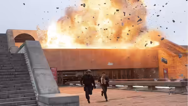 Two men running from a massive explosion outside a modern building