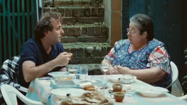 Sylvain (Vincent Macaigne) eating at a table with Francine (Francine Boulanger)