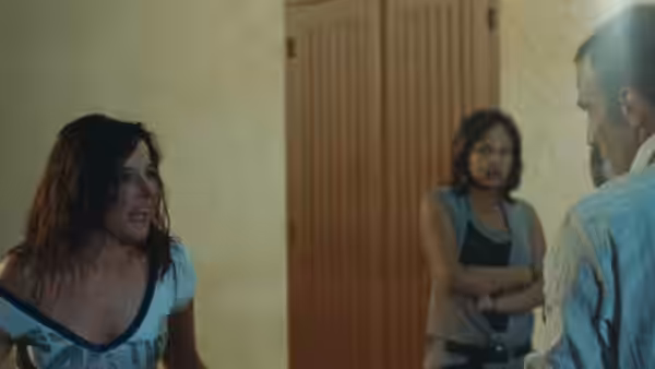 Patricia (Laure Calamy) facing a man indoors while another woman watches