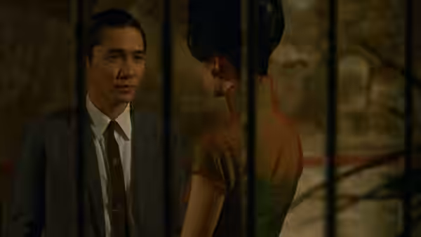 Chow Mo-wan (Tony Leung) faces Su Li-zhen (Maggie Cheung) through vertical bars