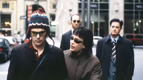 Hamlet (Ethan Hawke) walking on a city street beside a woman in sunglasses