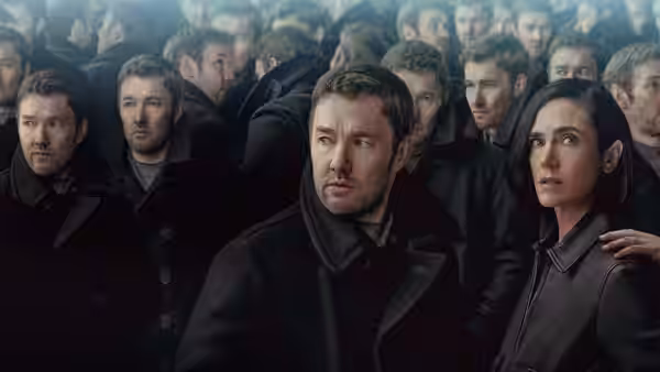 Joel Edgerton and Jennifer Connelly stand surrounded by identical men