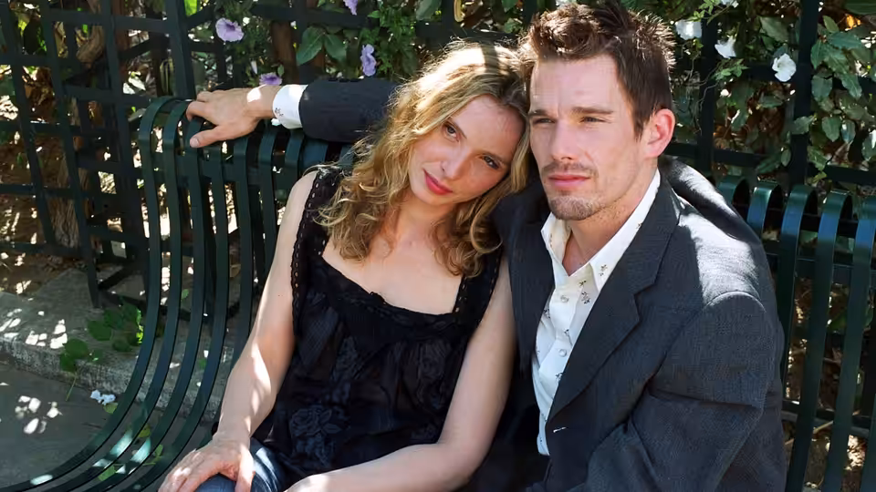 Jesse (Ethan Hawke) and Céline (Julie Delpy) sitting close on a green bench
