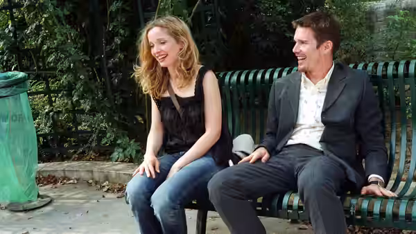 Jesse (Ethan Hawke) and Céline (Julie Delpy) laughing together on a bench