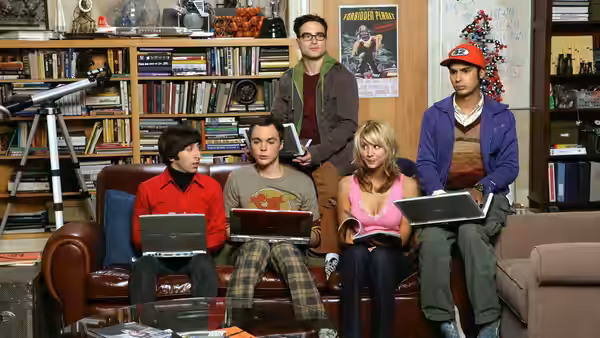 Leonard, Sheldon, Penny and Raj sit with laptops in the apartment living room