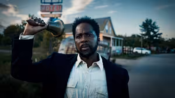 Boyd Stevens (Harold Perrineau) holding a bell high on a rural street