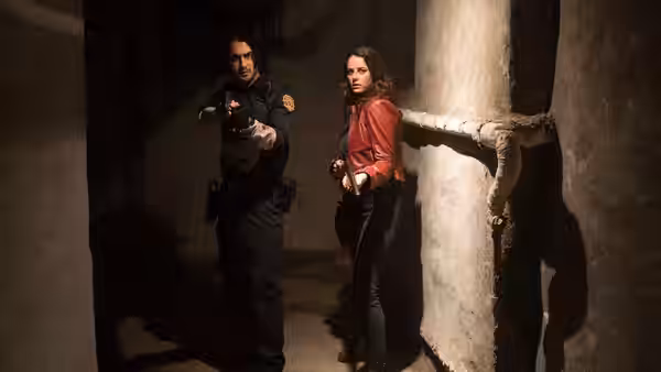 A police officer points his gun at Claire Redfield (Kaya Scodelario) in a concrete corridor