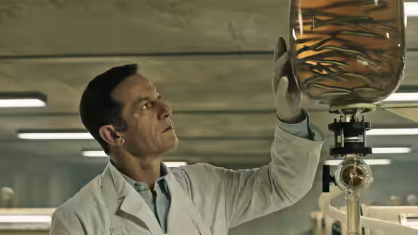 Volmer (Jason Isaacs) examines eels in a glass vessel