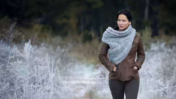 Katniss Everdeen (Jennifer Lawrence) standing on a frosty path with hands in pockets