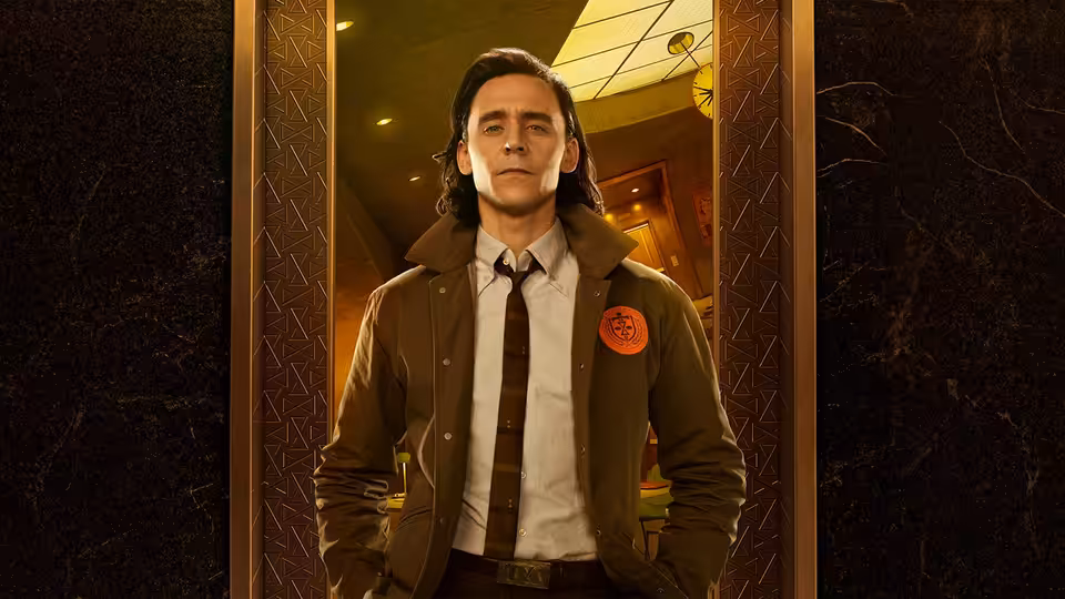 Loki (Tom Hiddleston) stands in an ornate doorway with hands in pockets