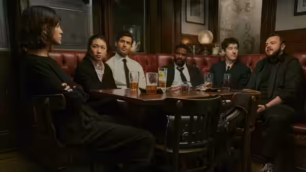 Six people seated around a table in a red booth