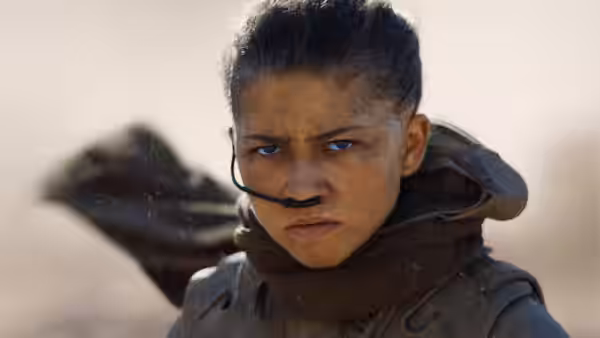 Chani (Zendaya) in desert gear stares ahead beneath a wrapped scarf