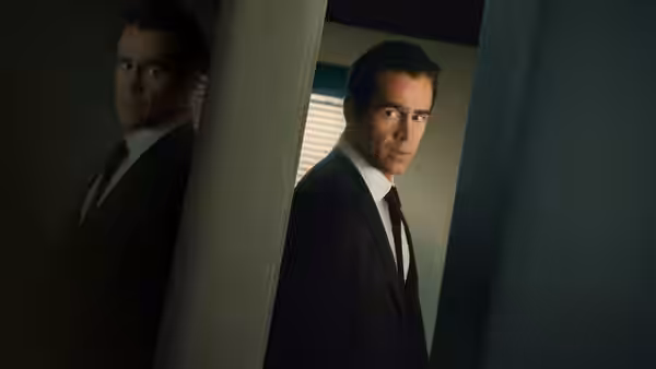 John Sugar (Colin Farrell) standing between pillars in a dim interior