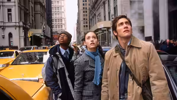 Sam Hall (Jake Gyllenhaal) and two companions looking upward on a city street