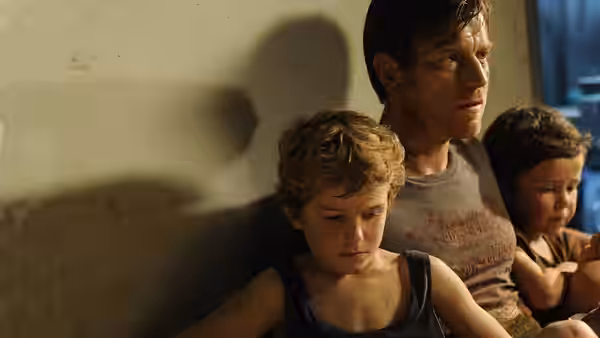 Henry Bennett (Ewan McGregor) stands with his sons inside a dim room