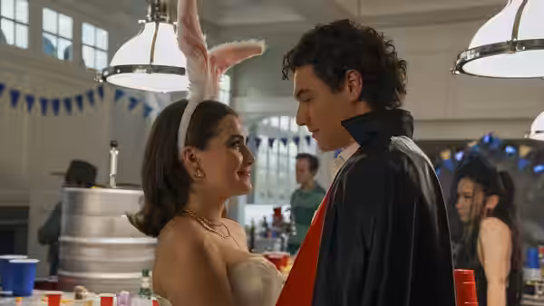 Woman wearing bunny ears faces man in vampire costume at a party